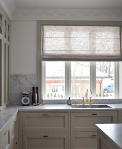 Grå hissgardin i köksfönster