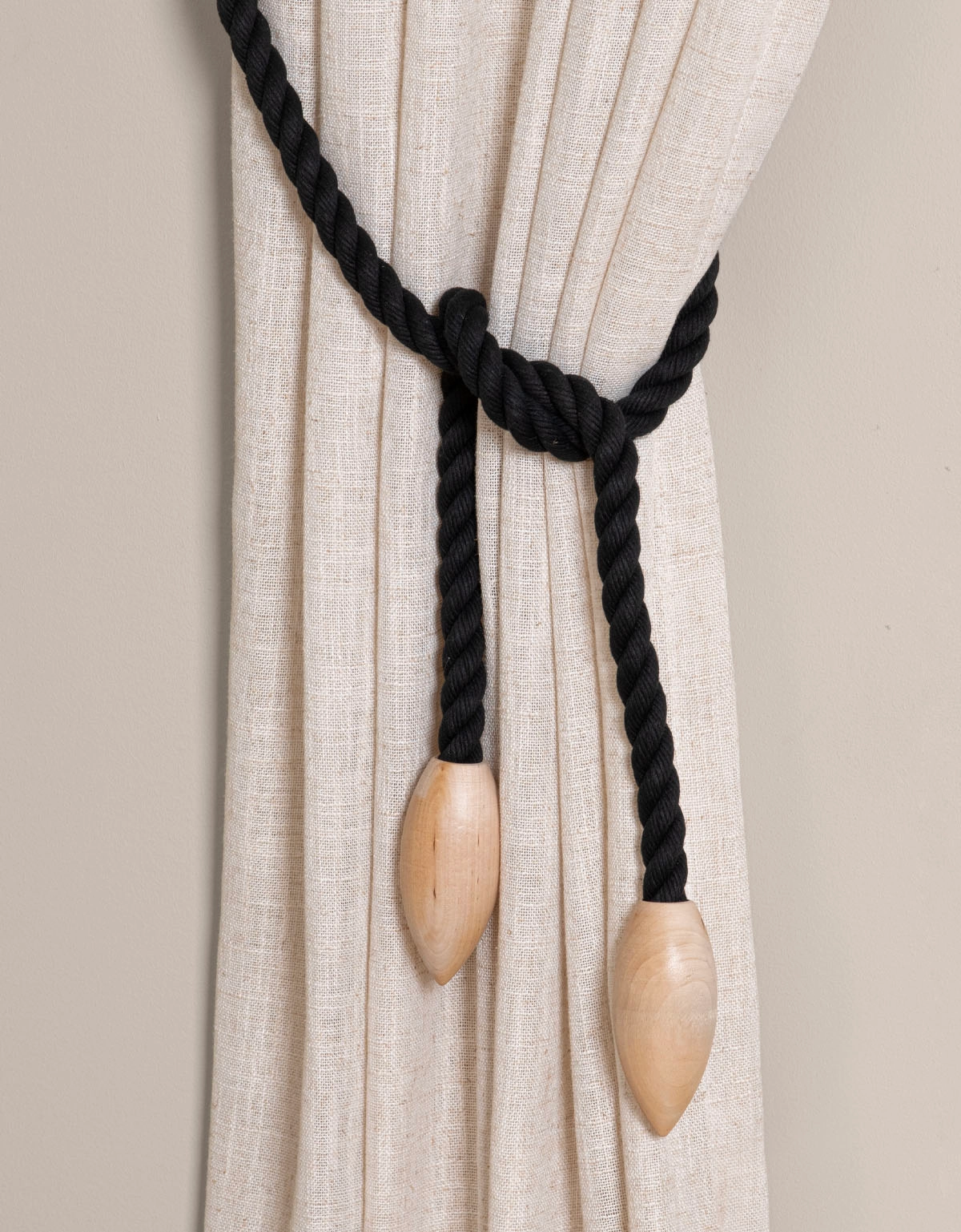 Svart gardinomtag med knoppar i trä