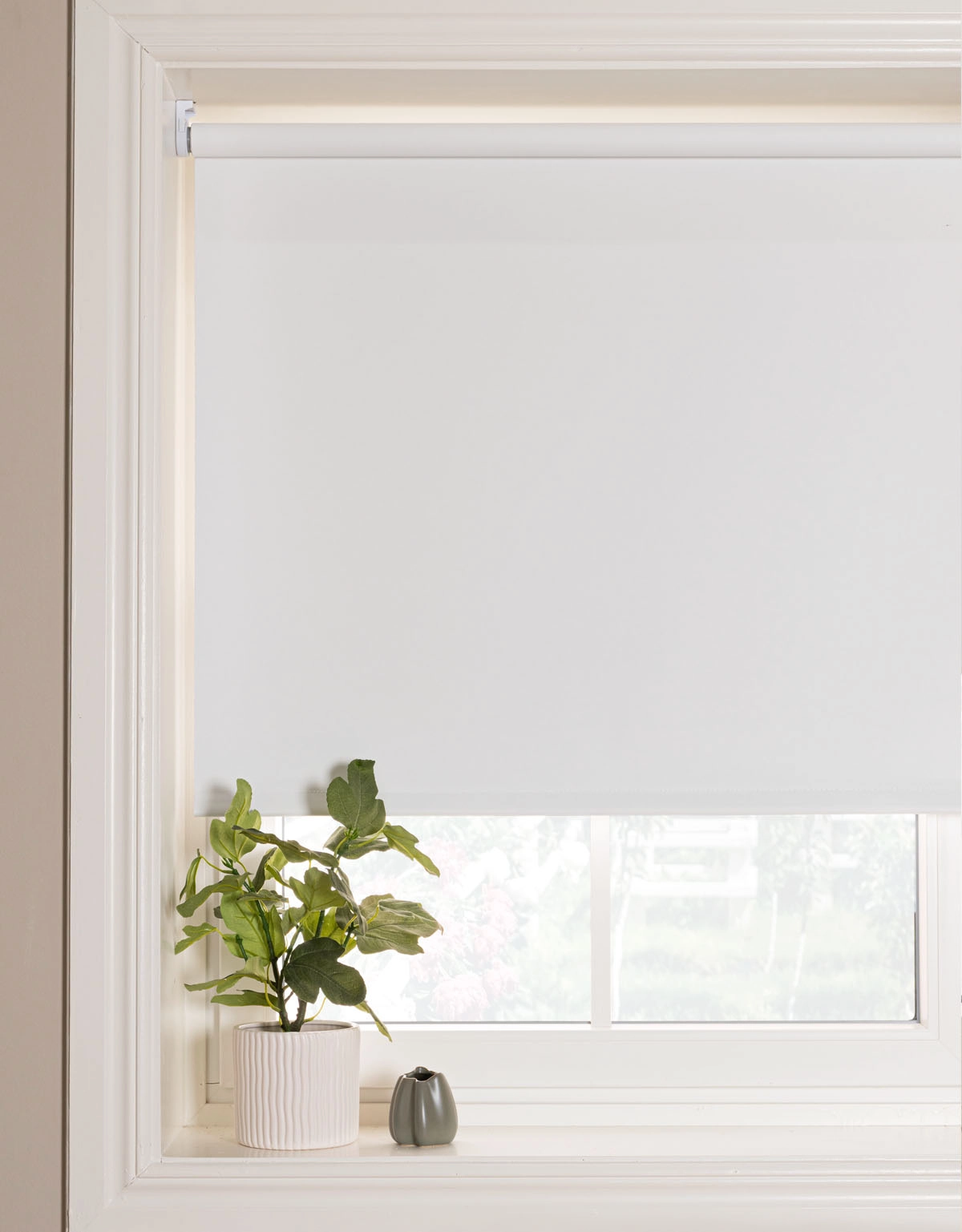Vit mörkläggande rullgardin monterad i nisch