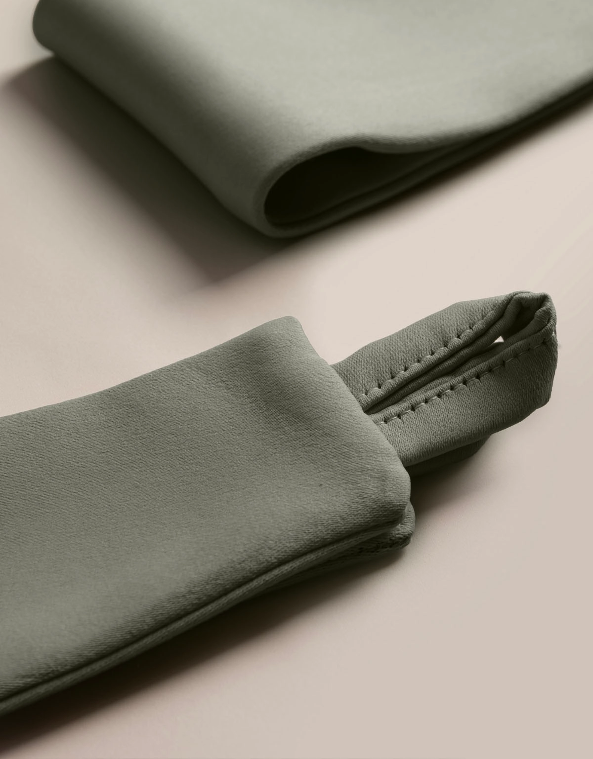 Närbild på mörkgrönt gardinomtag i tyg