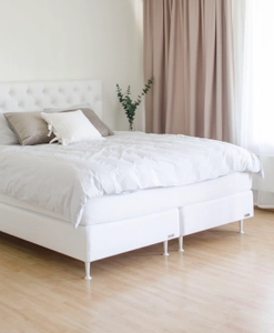 Vit säng med vita sängben