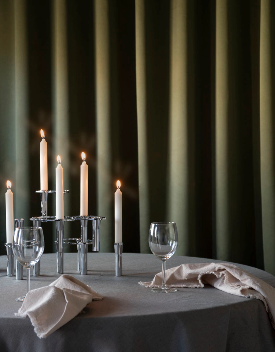 Grön gardin bakom ett bord med tända ljus