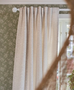 Ljusgrå bouclégardin på vit gardinstång