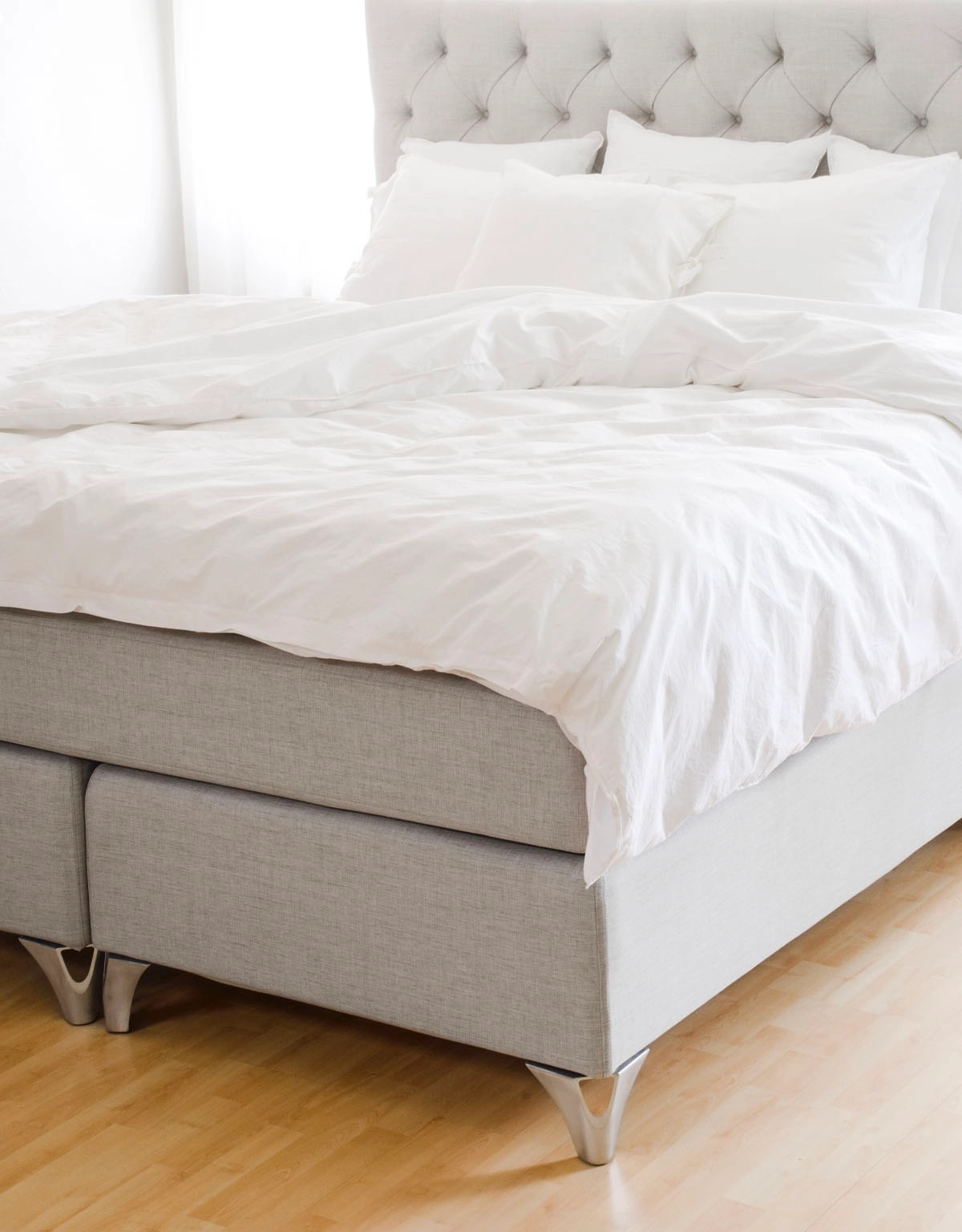 Sängben i stål på ljusgrå säng