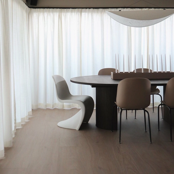 Vit gardin på svart gardinskena monterad på vägg