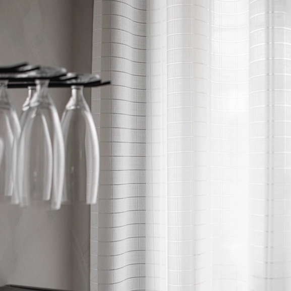 Made-to-measure Minna curtain with a die-cut check pattern in the dining room.