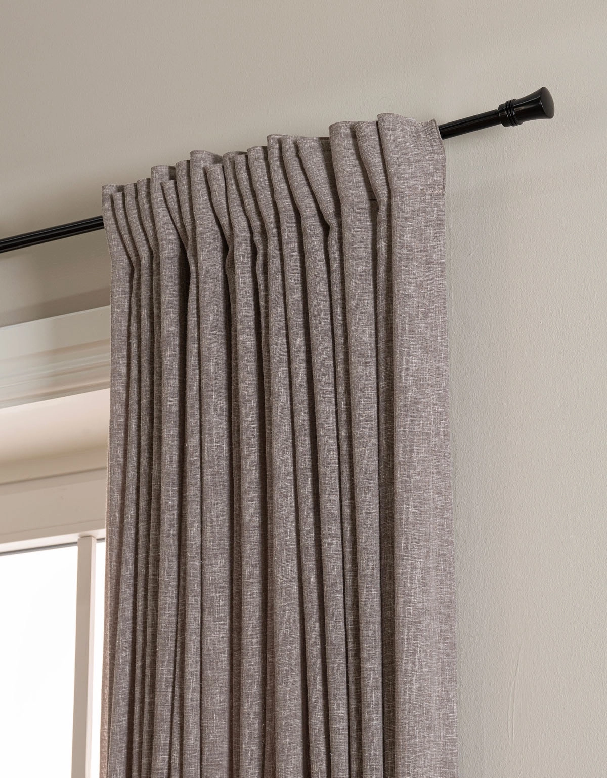 Svart gardinstång med dekorativ ändknopp