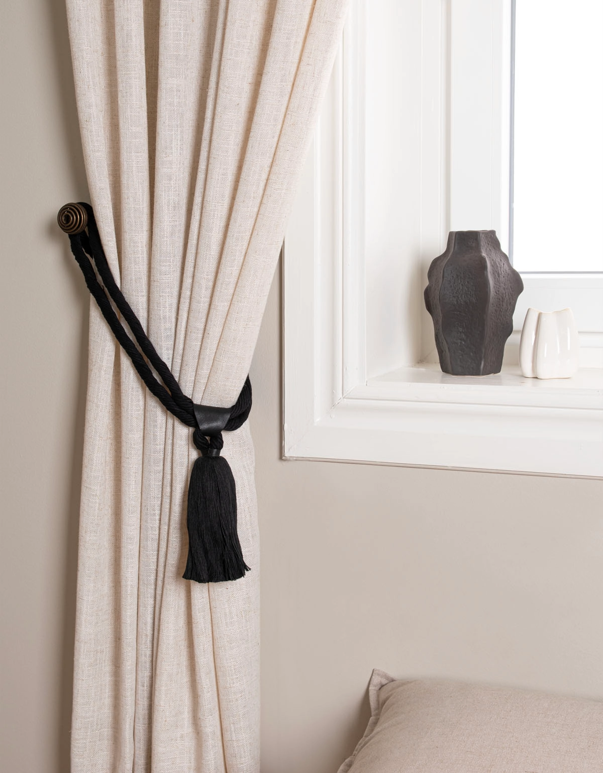 Svart gardinomtag med tofs och detalj i läder
