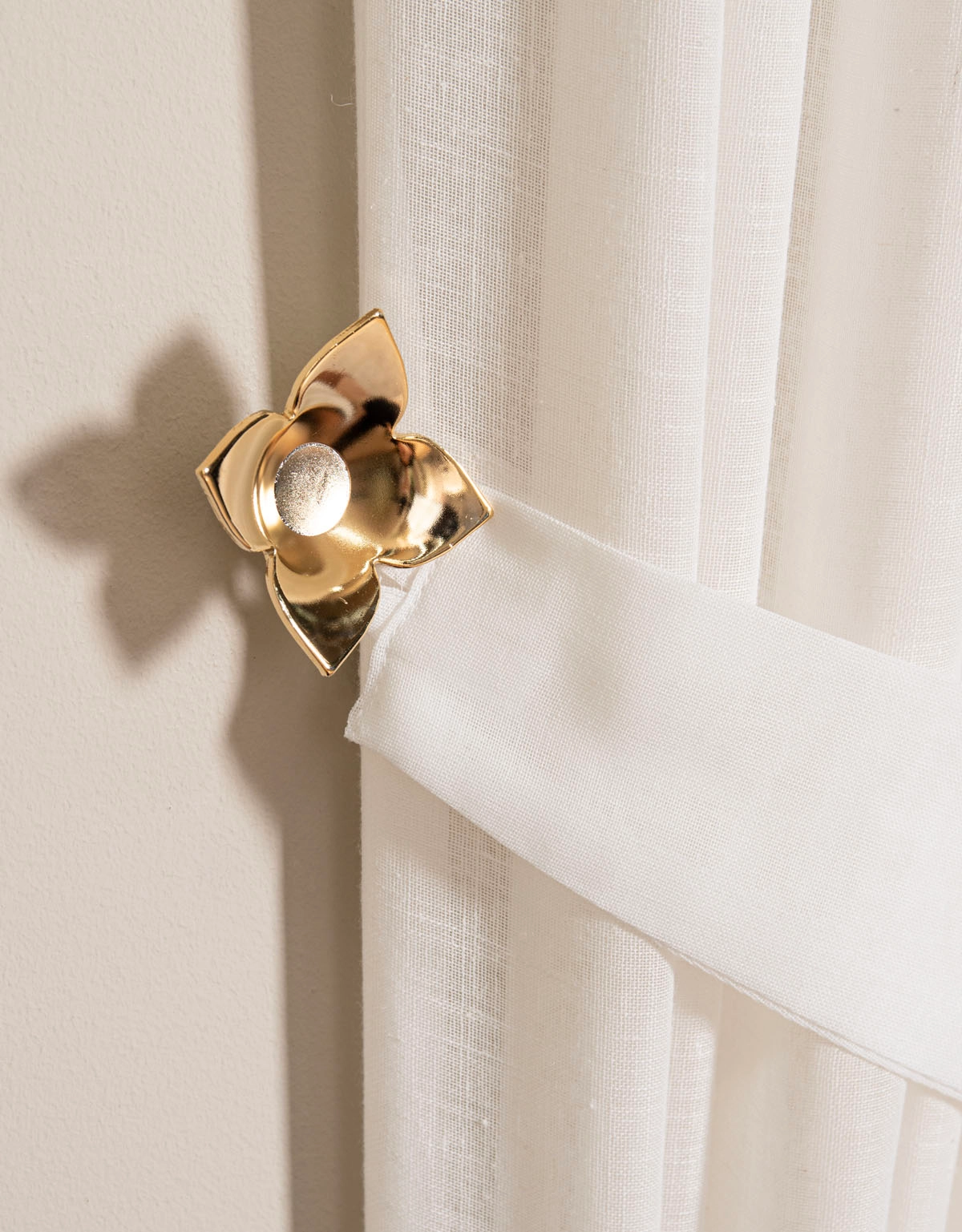 Fäste till gardinomtag i form av en guldig ros