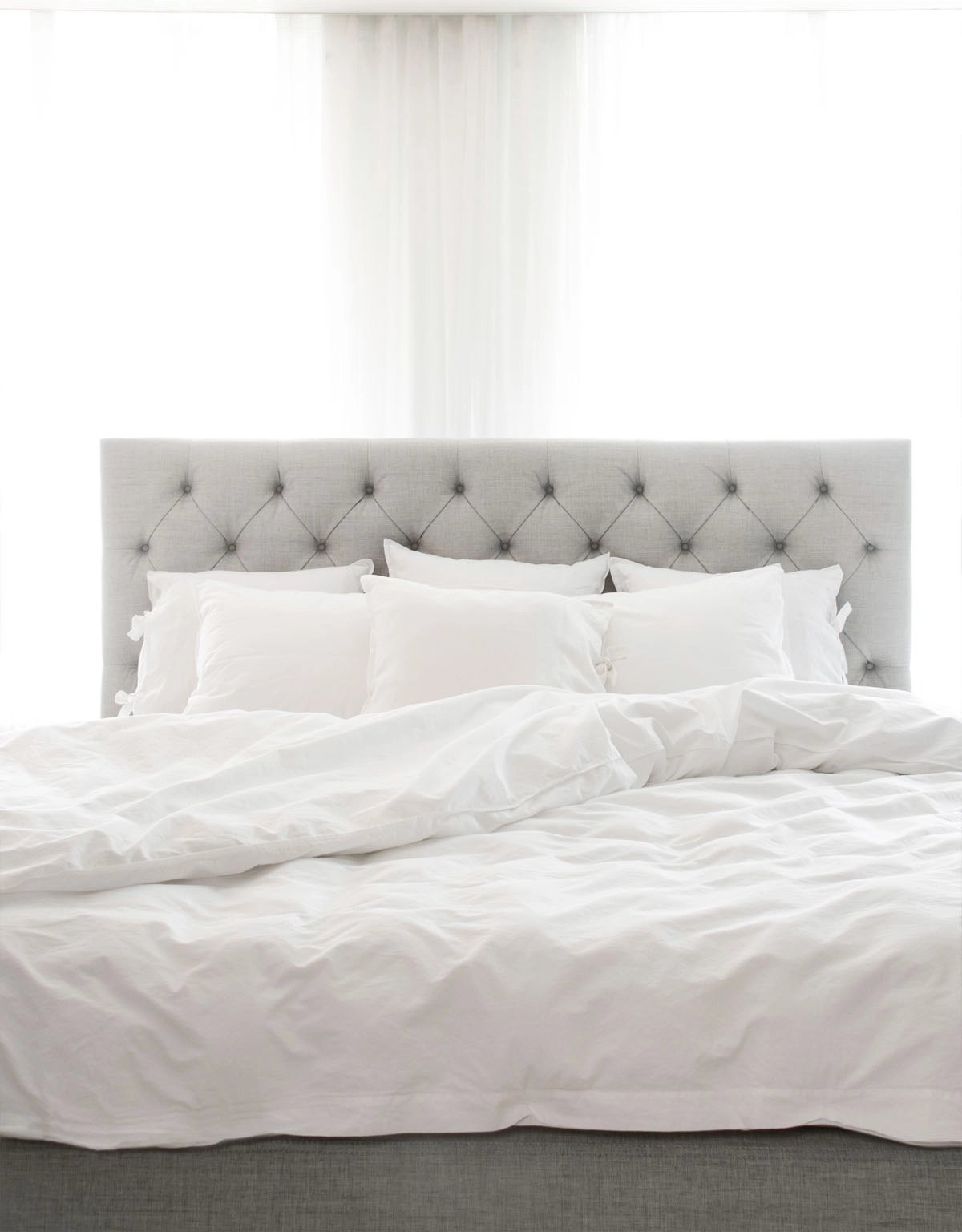 Ljusgrå sänggavel med knappar