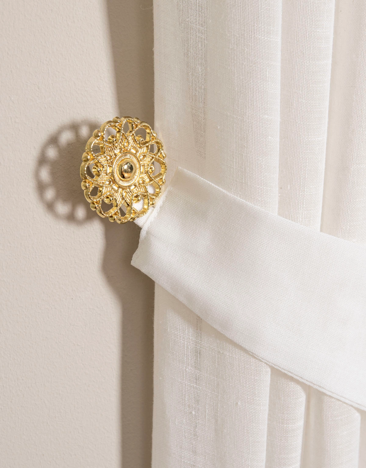 Fäste till gardinomtag i romatinisk och snirklig stil