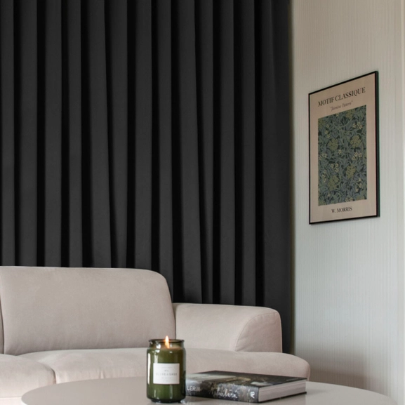 Svart mörkläggningsgardin på skena i vardagsrum