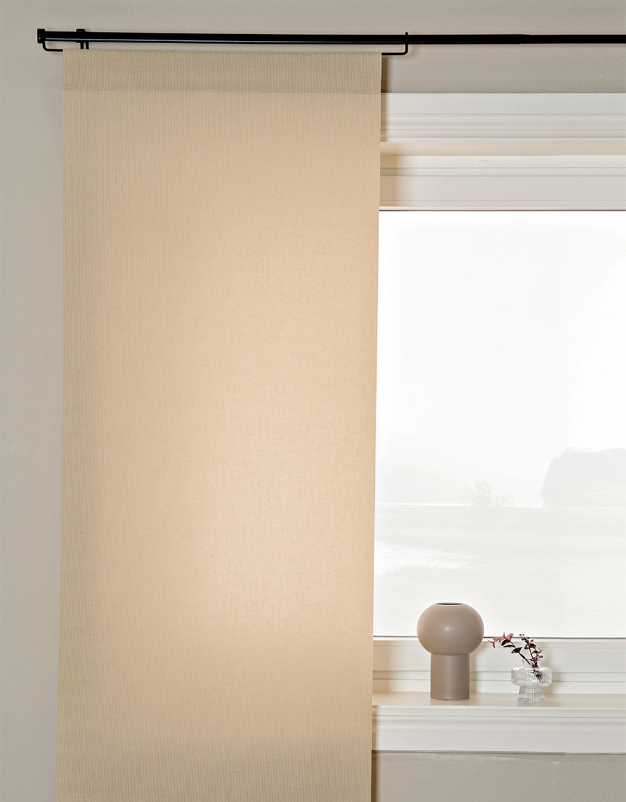 Beige panelgardin på gardinstång med panelhängare