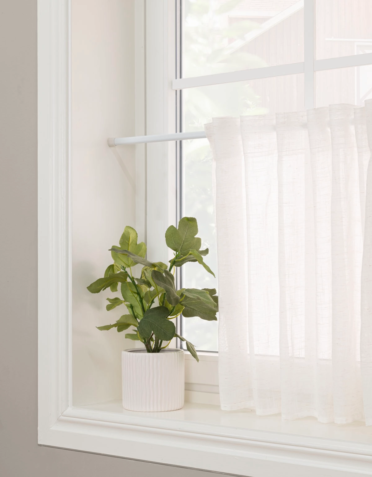 Vit spännstång med cafégardin i fönster