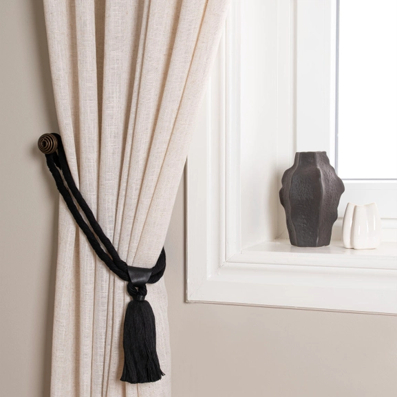 Svart gardinomtag med tofs och detalj i läder