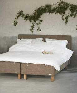 Sängben i ek på en brun säng i lantlig miljö