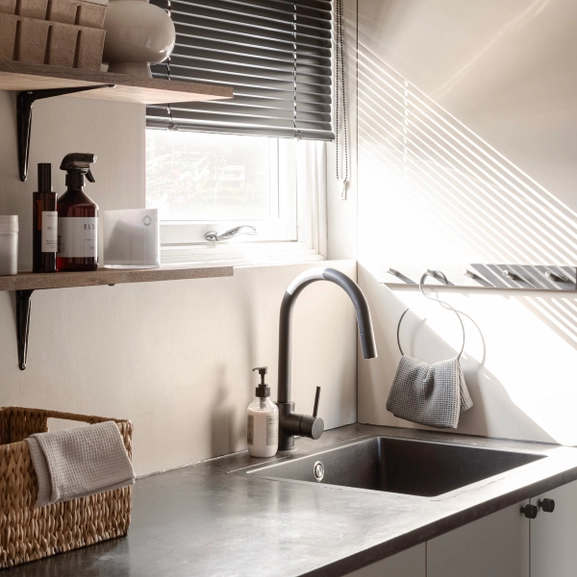 Svart persienn i tvättstuga