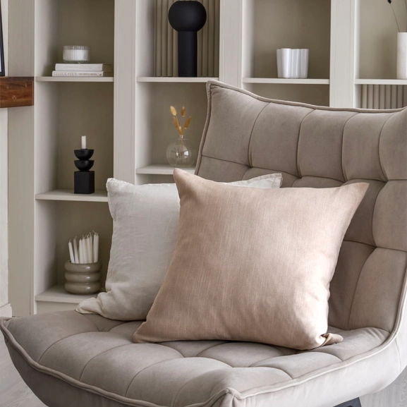 Kuddfodral i beiget och vitt i fotölj