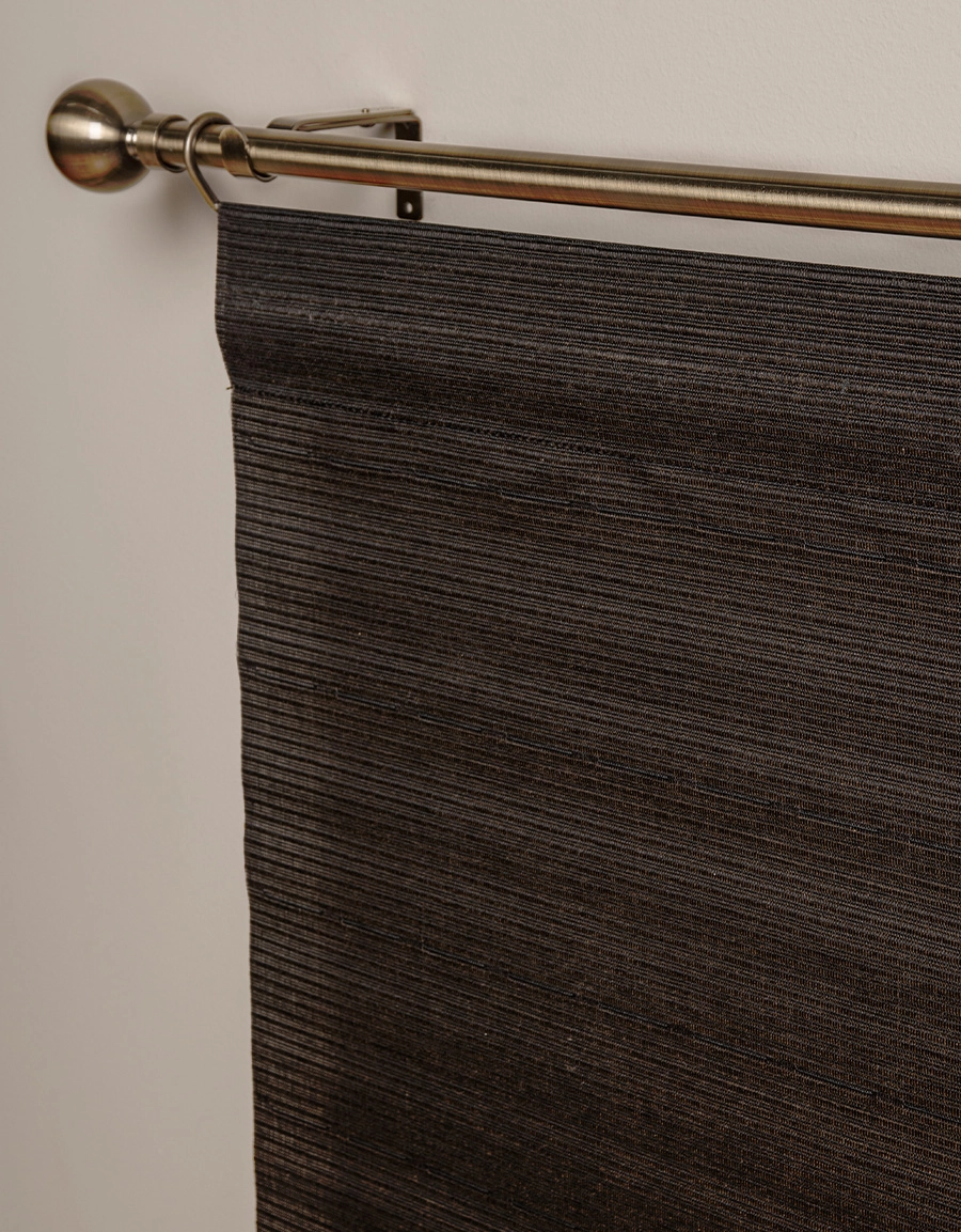 Närbild på mörkbrun panelgardin med struktur