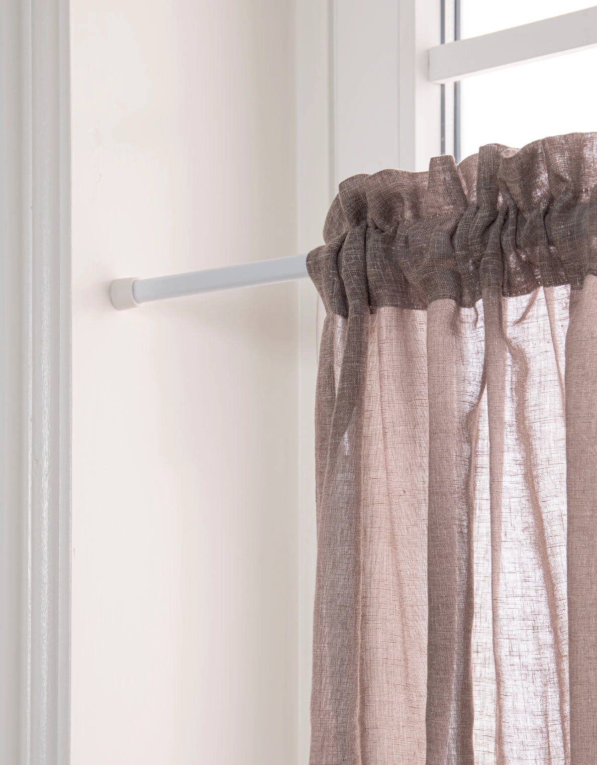 Vit spännstång med cafégardin i fönster