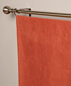 Närbild på orange panelgardin i mocka