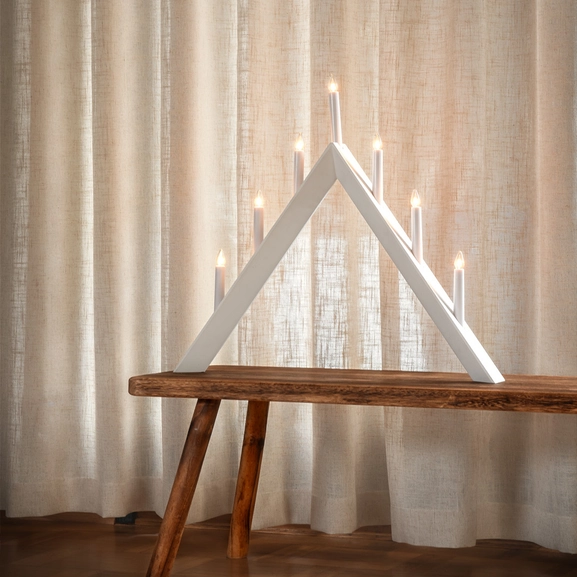 Beige gardin bakom ljusstake.