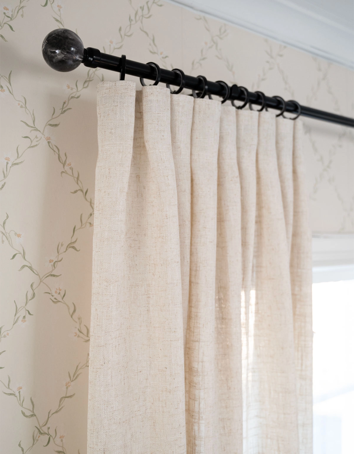 Svart gardinstång med beige gardin