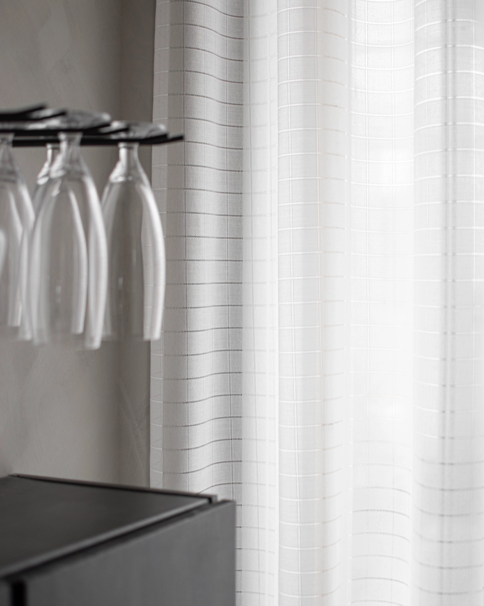 Made-to-measure Minna curtain with a die-cut check pattern in the dining room.