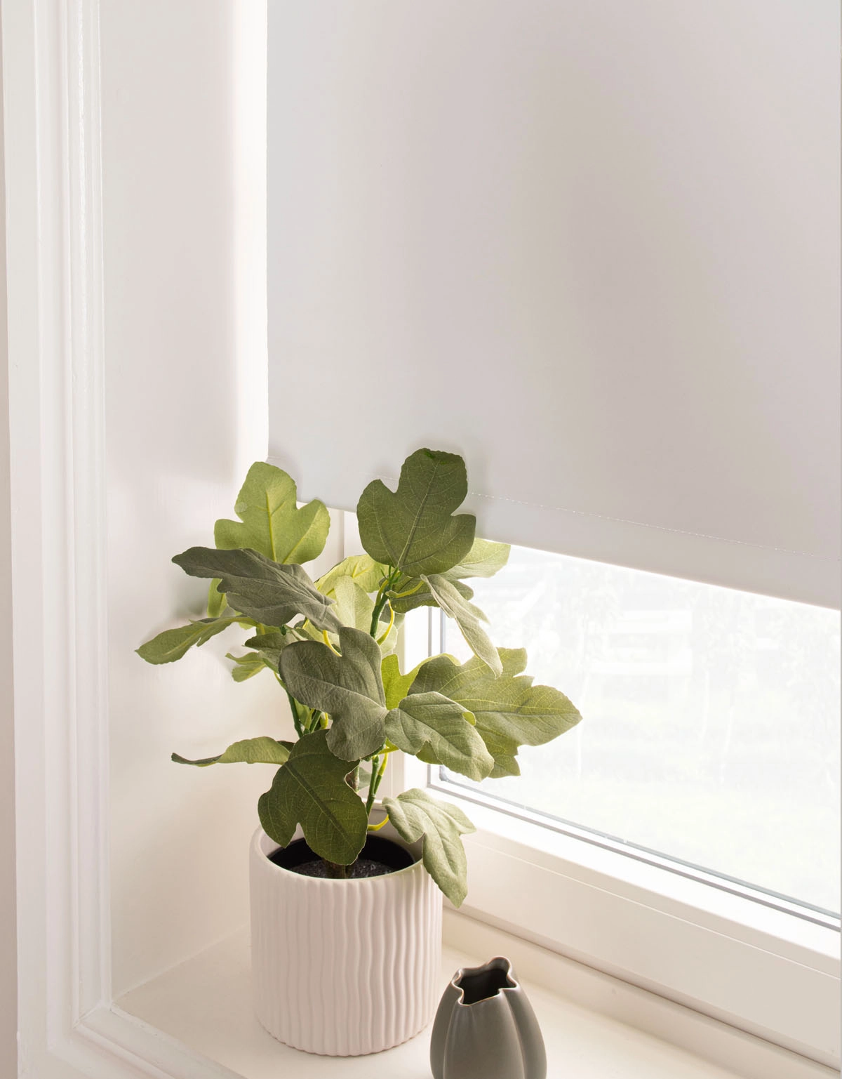 Närbild på vit mörkläggande rullgardin med insydd bottenlist