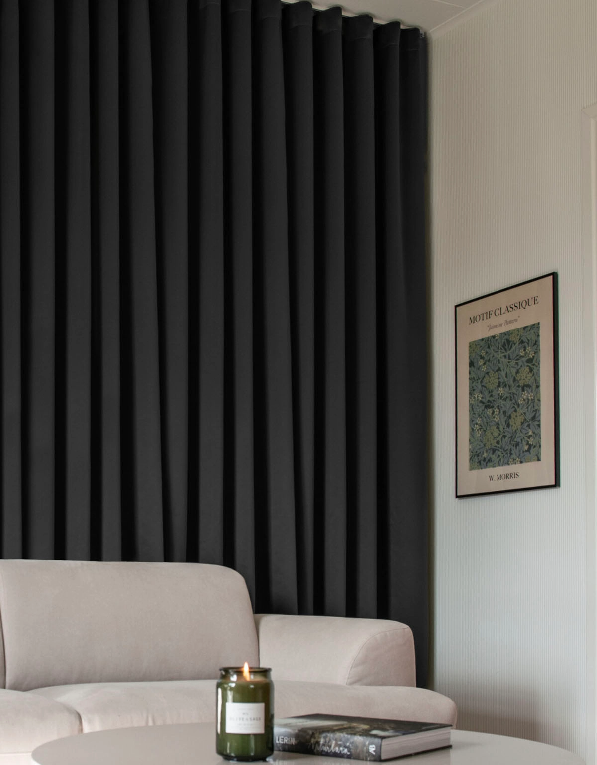 Svart mörkläggningsgardin på skena i vardagsrum