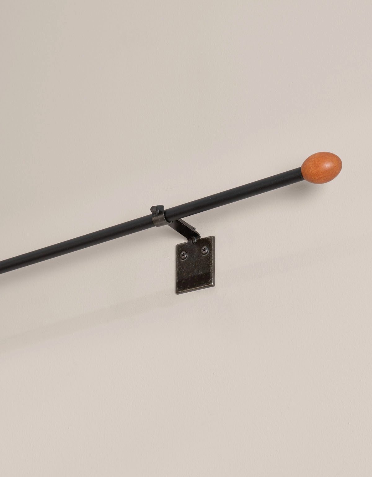 Svart gardinstång med oval knopp i trä