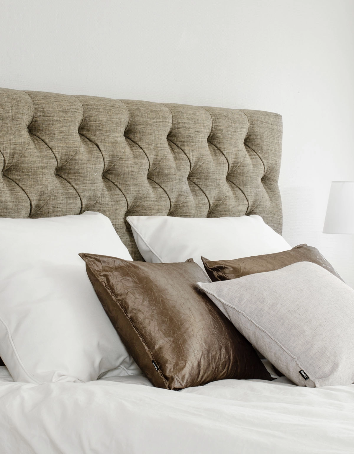 Brun sänggavel med klädda knappar