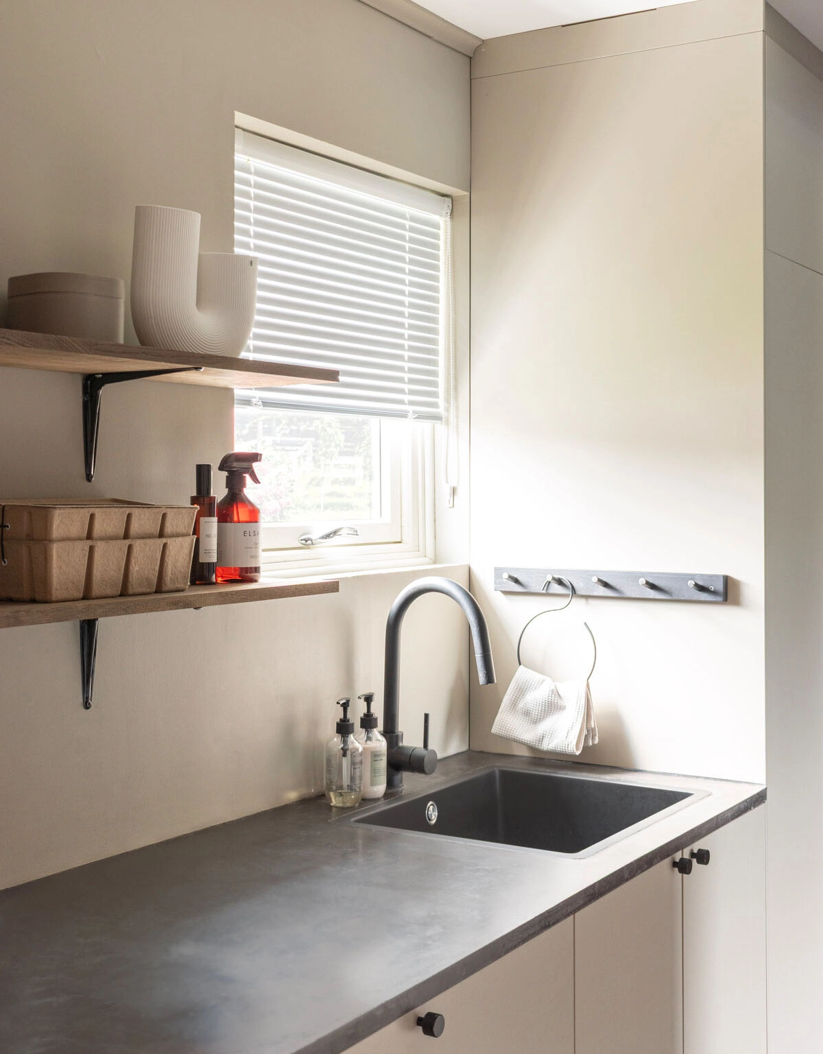 Vit persienn med skruvfri montering i tvättstuga