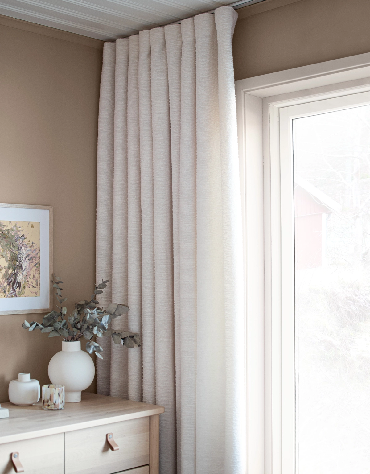 Vit bouclégardin i beiget rum