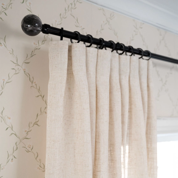 Svart gardinstång med beige gardin
