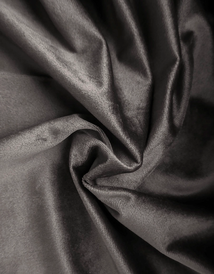 Närbild på gardintyg i mörkgrå sammet