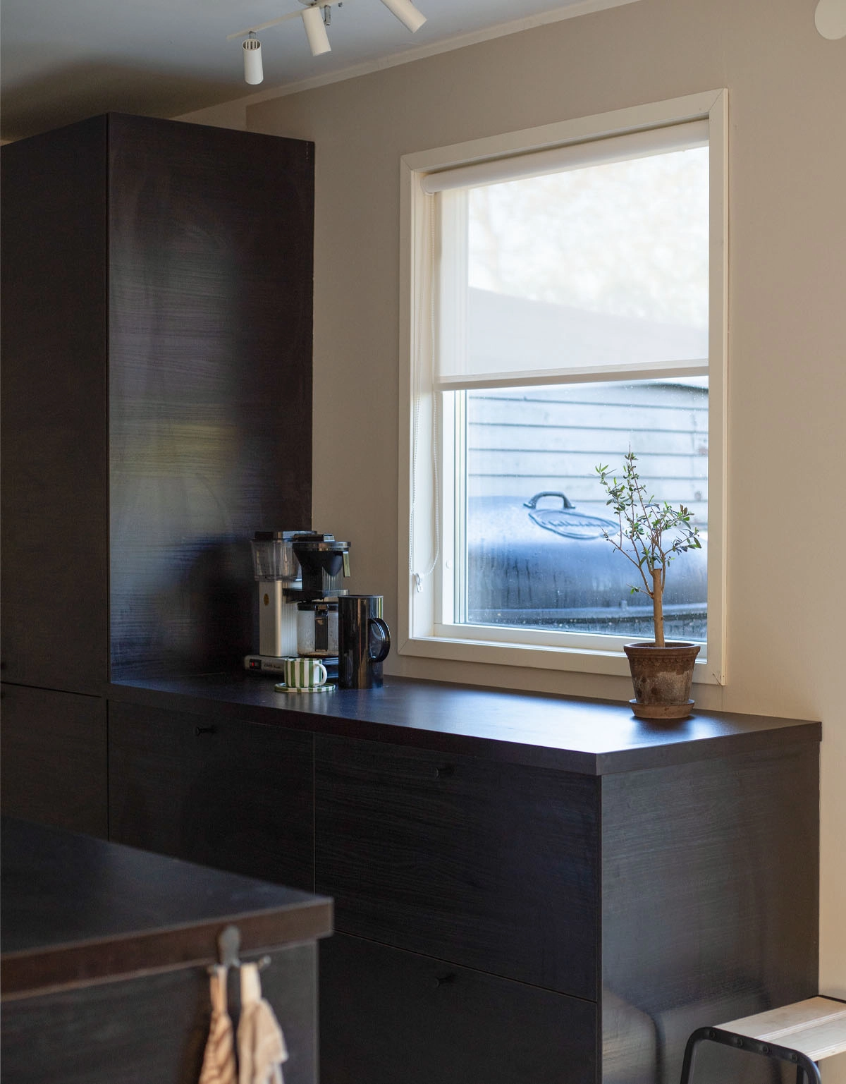 Skruvfri rullgardin i vit screenväv ovanför köksbänk