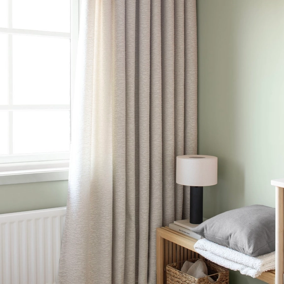 Grå bouclégardin i grönt rum