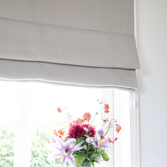 Mörkläggande ljusgrå hissgardin i fönster