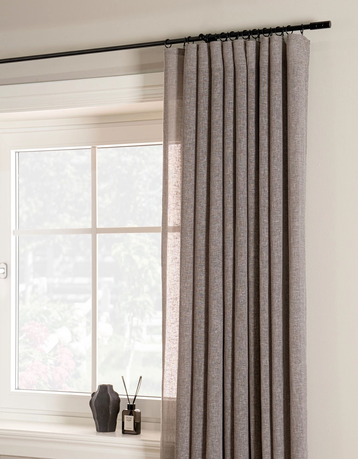 Skir gardin i greige färg på svart gardinstång