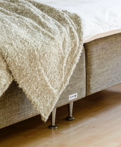 Sängben i aluminium på en brun säng