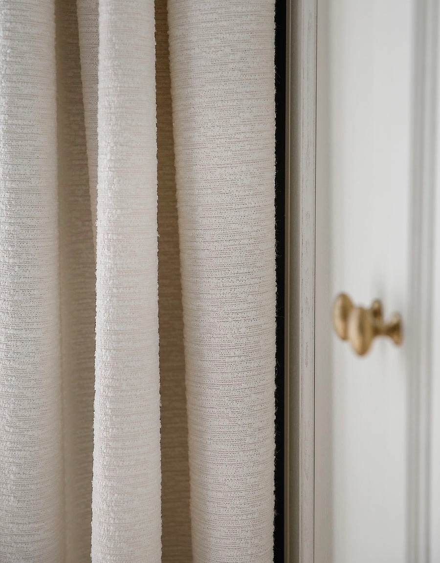 Närbild på vit bouclegardin