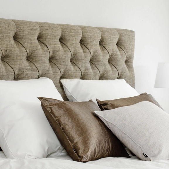 Brun sänggavel med klädda knappar