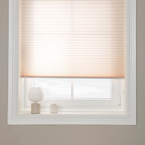 Beige plisségardin i fönster