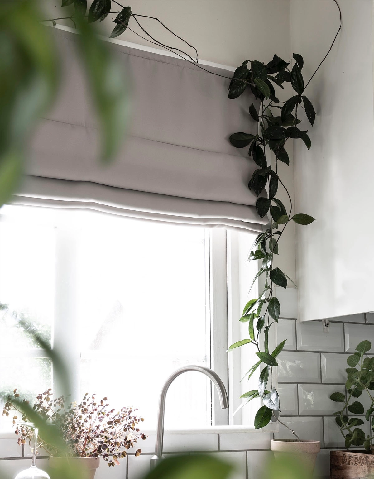 Mörkläggande ljusgrå hissgardin i kök