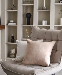 Kuddfodral i beiget och vitt i fotölj