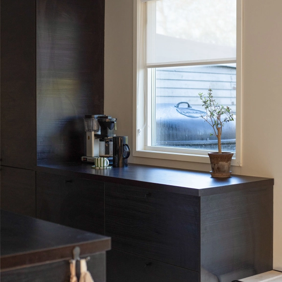 Skruvfri rullgardin i vit screenväv ovanför köksbänk