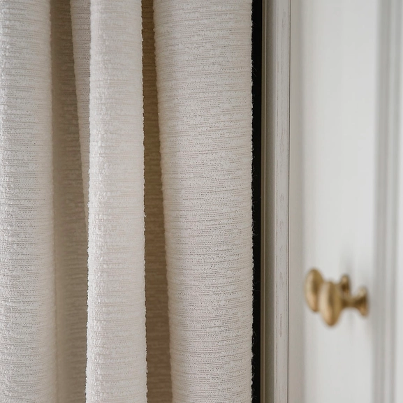 Närbild på vit bouclegardin