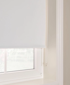 Närbild på vit mörkläggande rullgardin med kulkedja