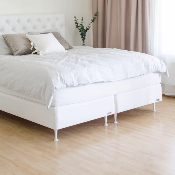 Vit säng med vita sängben